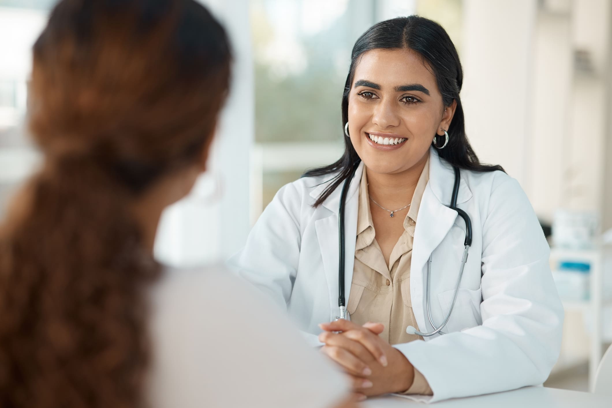 Shot of an attractive young doctor sitting with her patient during a consultation in her clinic